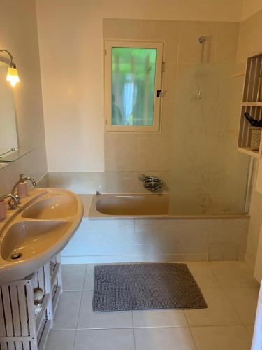 a bathroom with a bath tub and a sink at Villa Magnolia in Seillans