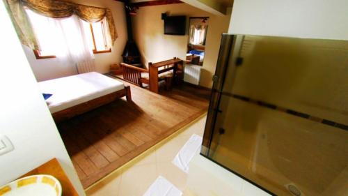 Habitación pequeña con cama y nevera. en Motel Tentação (Adult Only), en Canela