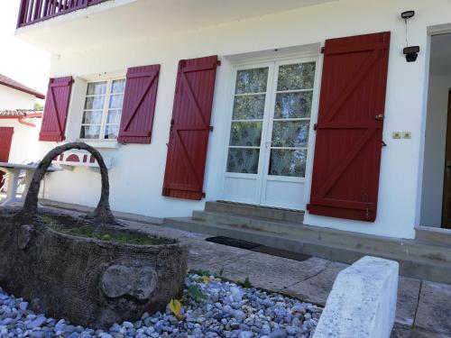 a white house with red doors and windows at Villa Rue Gainekoa in Cambo-les-Bains