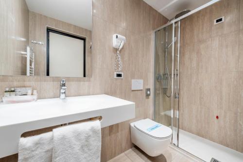 a bathroom with a sink and a toilet and a shower at Hotel Asnigo in Cernobbio