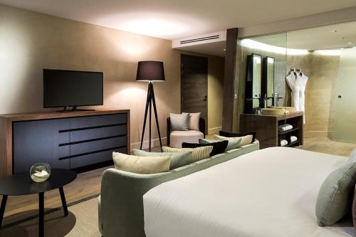 a hotel room with a bed and a television at Château de Bagnols in Bagnols