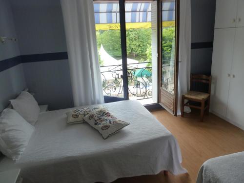 1 dormitorio con 1 cama y balcón con mesa en Auberge Les Tilleuls en Vincelottes