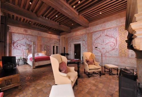 a bedroom with a bed and a room with chairs at Château de Bagnols in Bagnols
