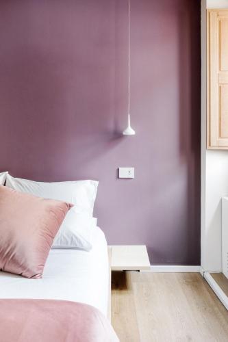 a bedroom with purple walls and a bed with a table at Via Del Centro Guesthouse in Oristano