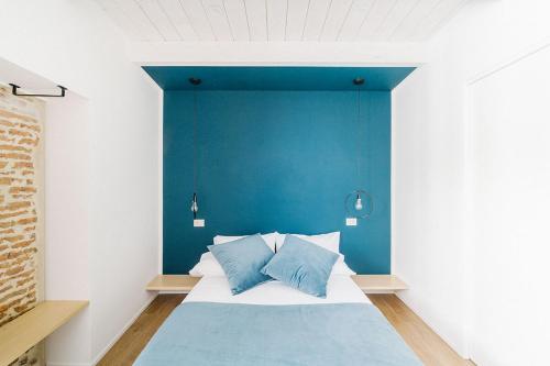 a bedroom with a blue wall and a bed at Via Del Centro Guesthouse in Oristano