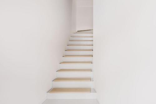 a staircase in a white room with white walls at Via Del Centro Guesthouse in Oristano