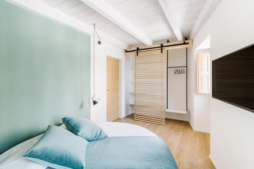 a bedroom with a bed with blue pillows on it at Via Del Centro Guesthouse in Oristano