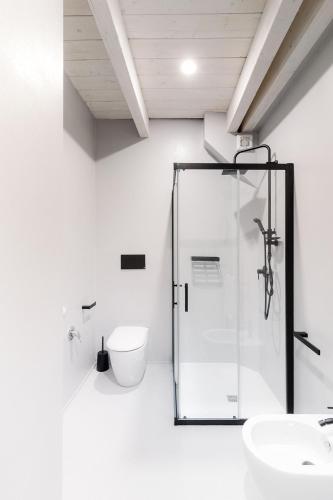 a bathroom with a glass shower and a toilet at Via Del Centro Guesthouse in Oristano