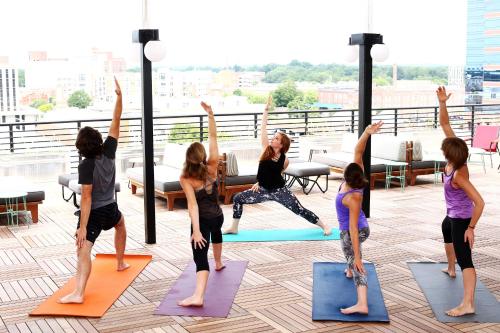 a group of people doing yoga on a rooftop at The Durham Hotel in Durham