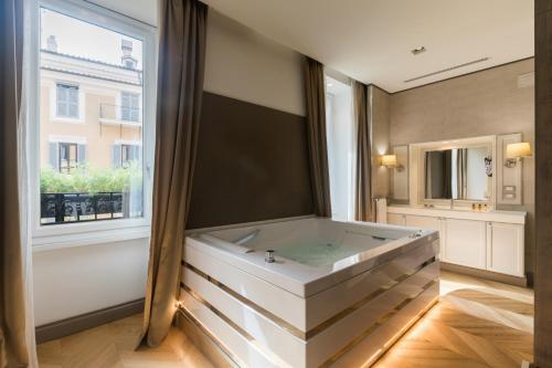 a large bath tub in a room with a window at San Carlo Suite in Rome