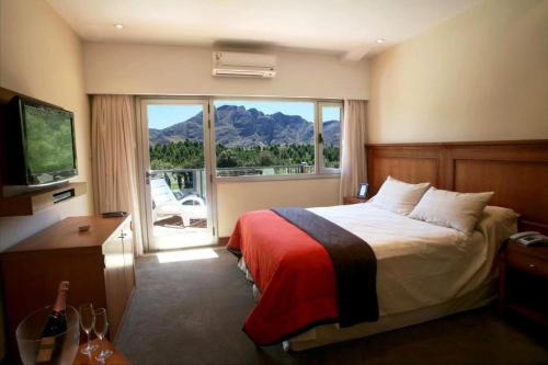 um quarto de hotel com uma cama e uma grande janela em El Mirador Complejo Turístico em Villa Ventana