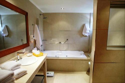 y baño con bañera, lavabo y espejo. en El Mirador Complejo Turístico en Villa Ventana