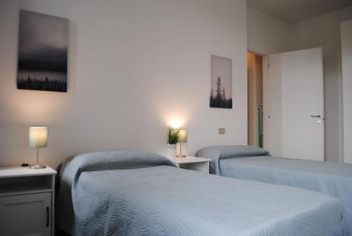 a bedroom with two beds and two lamps on tables at Bnbook Cascina Crennese in Gallarate
