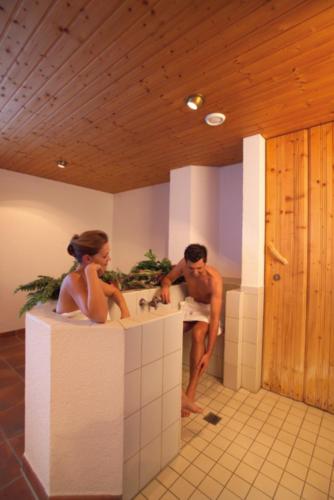 a man and a woman standing in a bathroom sink at Alpine Lifestyle Berghotel Madlener in Damuls