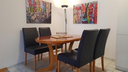 uma mesa de jantar com quatro cadeiras e um candeeiro em ALTSTADTGLÜCK - inklusive Privatparkplatz! em Lüneburg