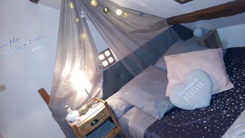une chambre avec un lit avec un oreiller bleu dans l'établissement Gîte maison de vacances La Chtite Normande, à Rugles