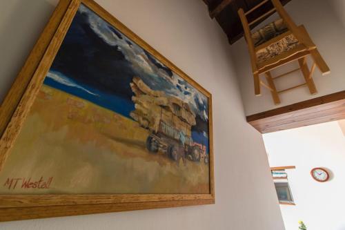 a painting of a train hanging on a wall at Samareitidos Light Cottage in Anaphotia