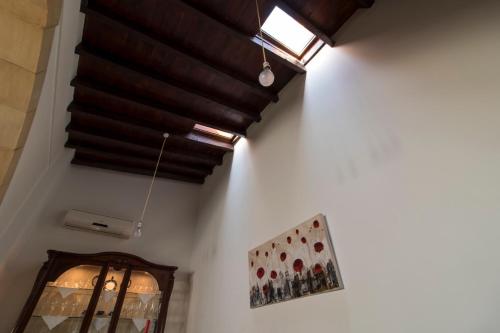 a room with a ceiling with a window and a picture at Samareitidos Light Cottage in Anaphotia