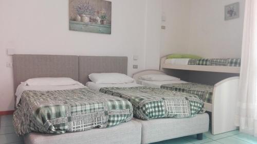 Habitación con 2 camas y 1 litera en Residence Ambra, en Riva del Garda