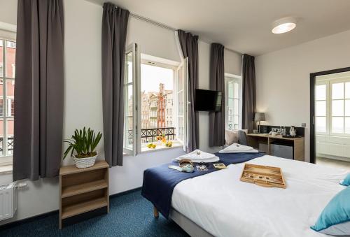 une chambre d'hôtel avec un lit et une fenêtre dans l'établissement Fama Residence Gdańsk Old Town, à Gdańsk