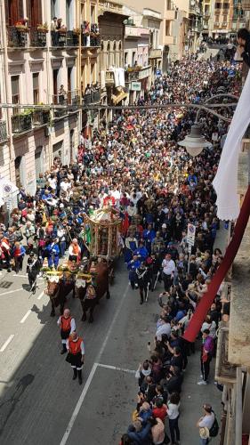 a large crowd of people watching a parade on a street at Marcus Suite in Cagliari