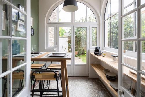 - une cuisine avec une table et quelques fenêtres dans l'établissement L'Echappee by Cocoonr, à Saint-Malo
