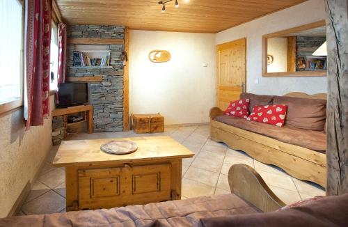 ein Wohnzimmer mit einem Sofa und einem Tisch in der Unterkunft Chalet la Lauzette in Bessans