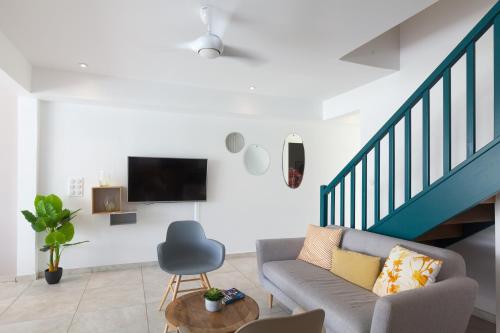 a living room with a couch and a tv at Villas Rock & Beach in Le Diamant