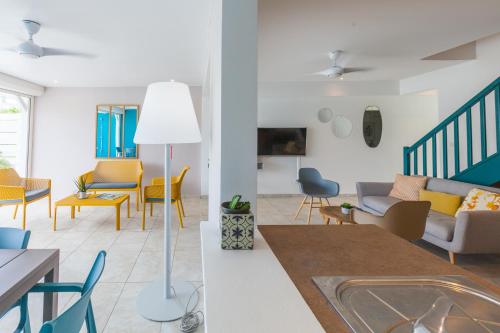 two views of a living room and dining room at Villas Rock & Beach in Le Diamant
