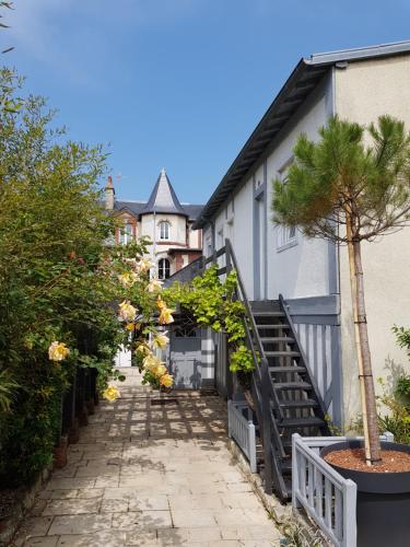 a walkway leading up to a house with a tree at Les Cabines in Houlgate