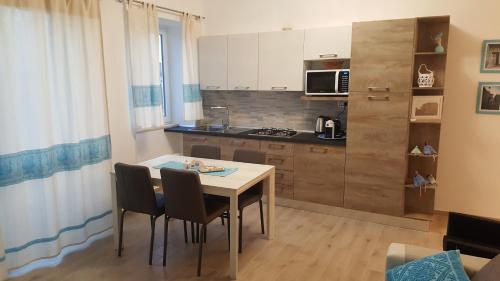 een keuken met een tafel en stoelen in een kamer bij Appartamento fronte porto in Alghero