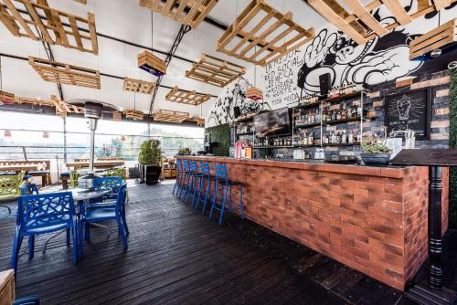 a bar with blue chairs and a brick wall at Hi Hotel Impala Queretaro in Querétaro