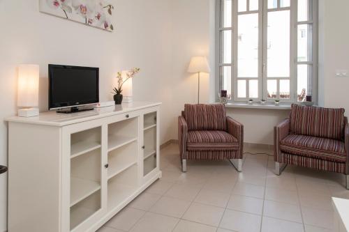 een woonkamer met een tv en 2 stoelen bij La Terrasse de Jules in Carcassonne