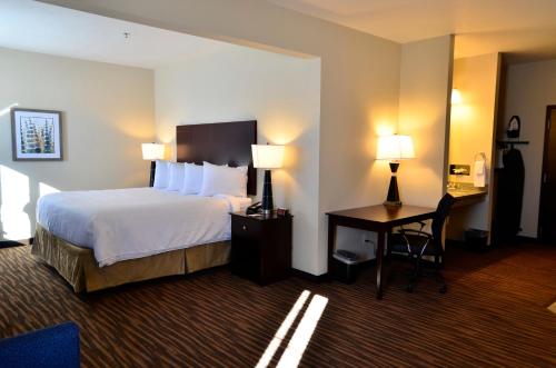 a hotel room with a bed and a desk with two lamps at Cobblestone Inn & Suites - Holstein in Holstein