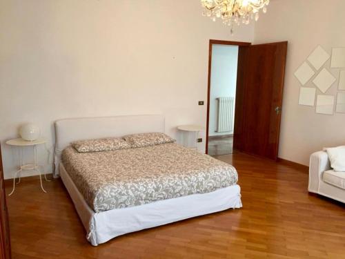 1 dormitorio con cama y lámpara de araña en Casa Mamma Mia, en Fiesso dʼArtico