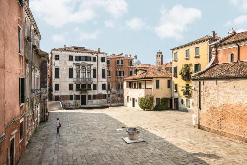 a person standing in the middle of a street at Ca' del Monastero 4 Collection Apartment up to 8 Guests with Lift in Venice