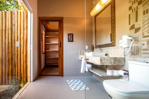 a bathroom with a toilet and a sink and a mirror at Pousada Recanto do Arraial in Arraial d'Ajuda