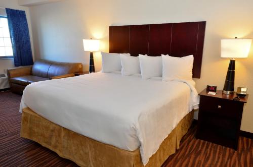 a hotel room with a bed and a dresser at Cobblestone Inn & Suites - Holstein in Holstein
