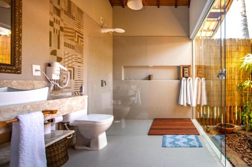 a bathroom with a toilet and a sink and a shower at Pousada Recanto do Arraial in Arraial d'Ajuda