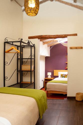 a hotel room with two beds and a lamp at Casa de La Chola in Ollantaytambo
