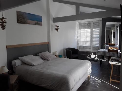 ein Schlafzimmer mit einem Bett und einem Schreibtisch. in der Unterkunft Les oyats in Le Crotoy