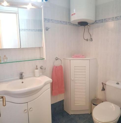a bathroom with a sink and a toilet and a mirror at Naxos Beachvilla in Plaka