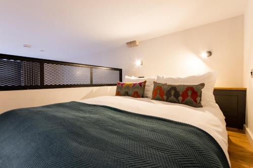 a bedroom with a large white bed with pillows at Linton Collection - Blackfriars Lofts in Edinburgh