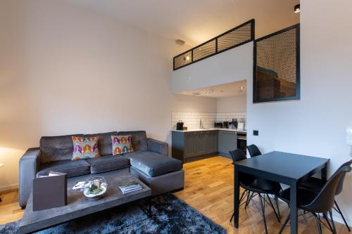 a living room with a couch and a table at Linton Collection - Blackfriars Lofts in Edinburgh