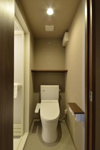 a bathroom with a toilet in a small room at Dormy Inn Takamatsu Chuo Koenmae Natural Hot Spring in Takamatsu