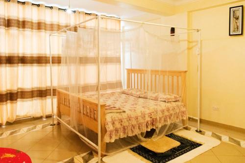 Mbarara的住宿－Meliva Guest House Mbarara，一间卧室,卧室内配有一张天蓬床