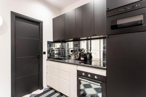 a kitchen with black appliances and a black refrigerator at CMG Nation - Reuilly B in Paris