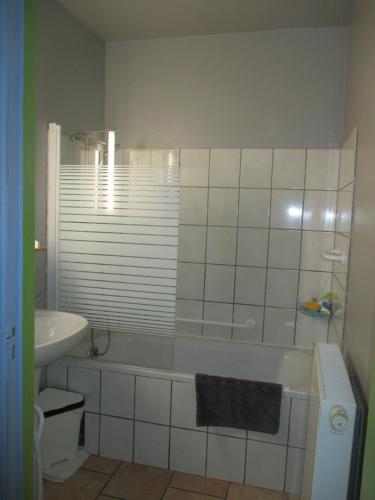 a bathroom with a tub and a toilet and a sink at gite air pur in Roisin