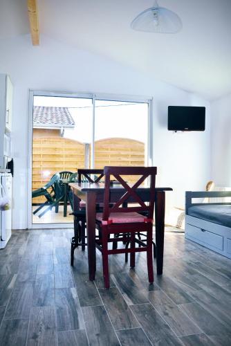 une salle à manger avec une table et des chaises et un balcon dans l'établissement La Hume Vacances, à Gujan-Mestras