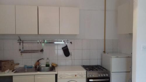 a kitchen with white cabinets and a sink and a stove at kod Elipse in Zagreb